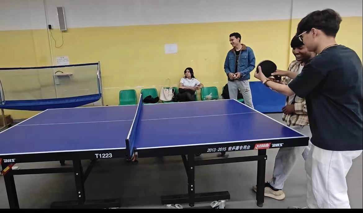 图为中国学生教授留学生学习乒乓球击球技巧